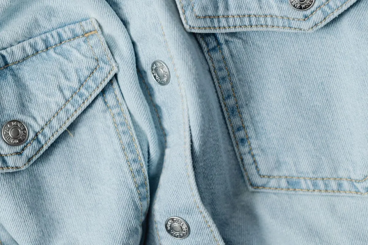 Silver metal buttons on a light denim shirt