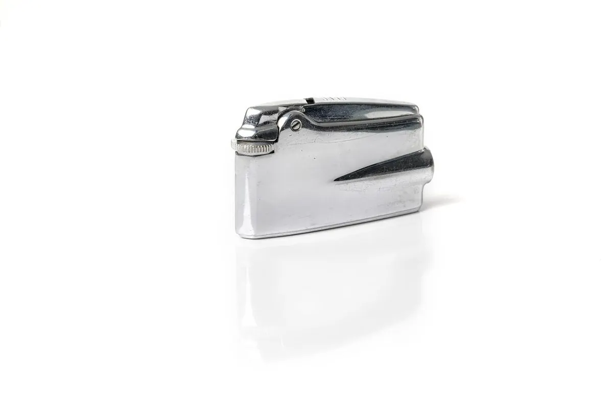 A silver metal refillable lighter on a white background