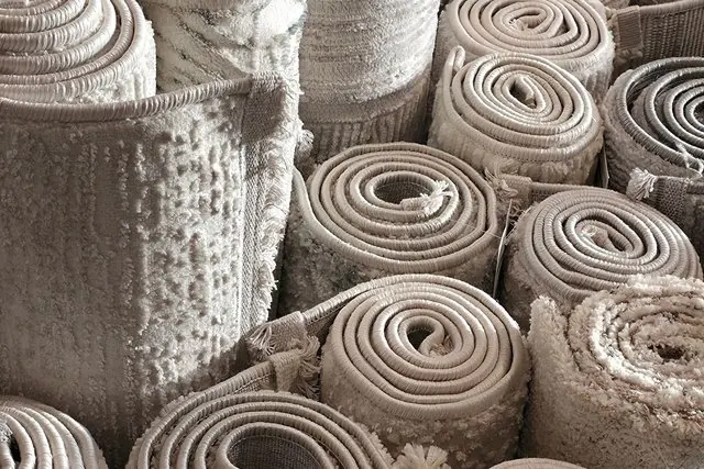 Nhiều cuộn thảm màu xám xếp trong cửa hàng